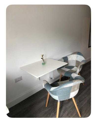 a white table and two chairs in a room at Skellig Port Accommodation - 1 Studio Bed Apartment in Portmagee