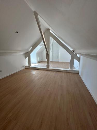 Cette chambre vide est dotée de parquet et de murs blancs. dans l'établissement L'arche de mémé, à Martigné-Briand