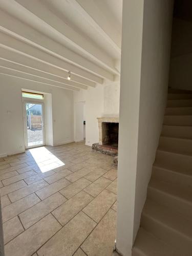 une pièce vide avec un escalier et une cheminée dans l'établissement L'arche de mémé, à Martigné-Briand
