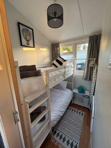 a small room with two bunk beds and a window at Welsh Bayview Retreat 2-Bed Lodge at Clarach Bay Holiday Village in Aberystwyth