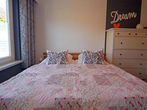 a bedroom with a bed and a dresser at Bungalow in Neubukow mit Terrasse und Garten in Neubukow