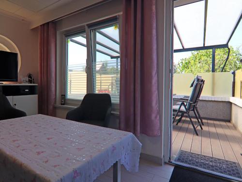 a room with a table and chairs and a balcony at Bungalow in Neubukow mit Terrasse und Garten in Neubukow
