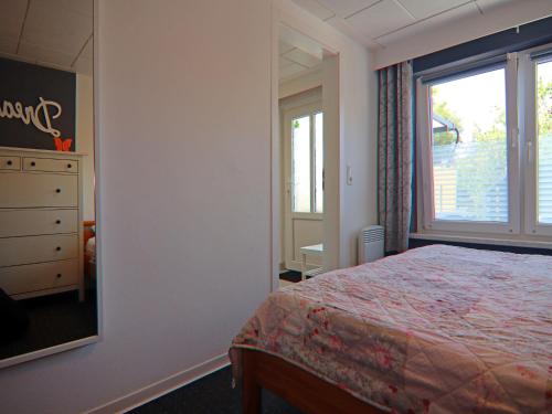 a bedroom with a bed and a dresser and a window at Bungalow in Neubukow mit Terrasse und Garten in Neubukow