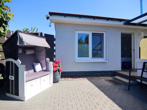 a small house with a bench and a window at Bungalow in Neubukow mit Terrasse und Garten in Neubukow