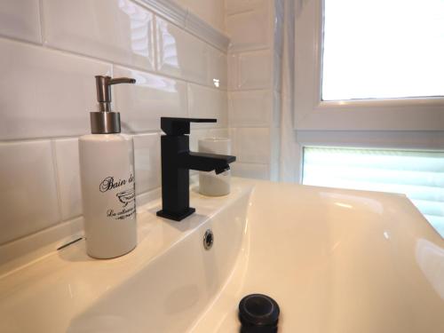 a bathroom sink with a soap dispenser on it at Bungalow in Neubukow mit Terrasse und Garten in Neubukow