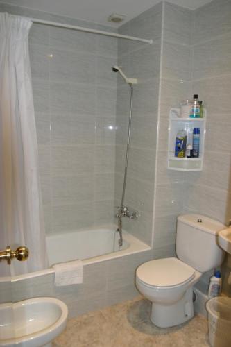 a bathroom with a toilet and a shower and a sink at Hostal Sa Prensa in Ciutadella