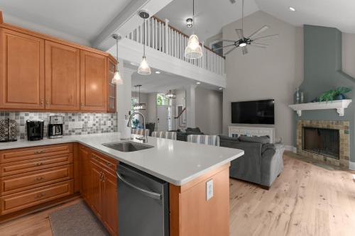 a kitchen with a sink and a living room at Making Waves by AvantStay Sleeps 20 Pool in Westport