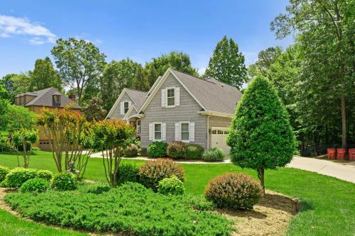 a house with a yard with bushes and trees at Making Waves by AvantStay Sleeps 20 Pool in Westport