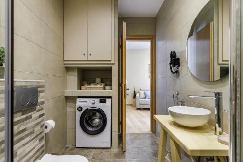 a bathroom with a washing machine and a sink at Anemelo Home in Skopelos Town