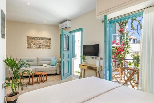 a bedroom with a bed and a living room with a couch at Anemelo Home in Skopelos Town