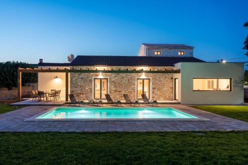 a villa with a swimming pool in front of a house at Villa Veduta in Bale