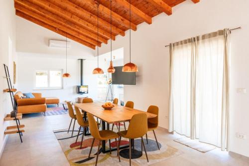 una sala da pranzo e un soggiorno con tavolo e sedie in legno di Villa Veduta a Bale (Valle)