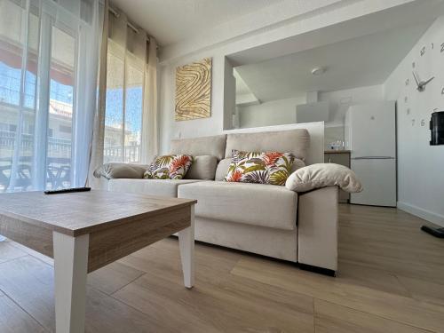 een woonkamer met een bank en een tafel bij SATORI Romantyczny azyl dla dwojga 150 m od plaży - apartament z balkonem i parkingiem, Playa de Gandia in Playa de Gandia