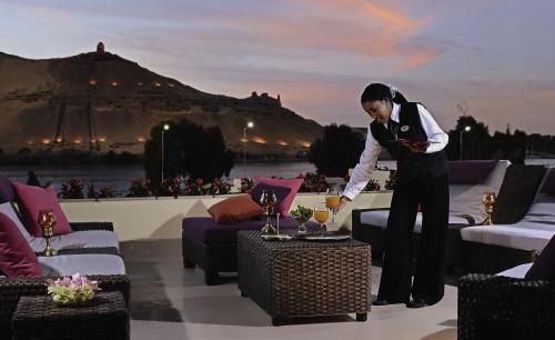 a woman standing in a room with a glass of wine at Mövenpick Resort Aswan in Aswan
