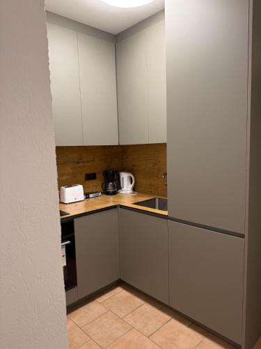 a small kitchen with white cabinets and a sink at Ferienwohnung in Soltau in Soltau
