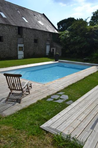 une chaise assise sur une terrasse à côté d'une piscine dans l'établissement Longère entre mer et campagne avec piscine, à Pluguffan