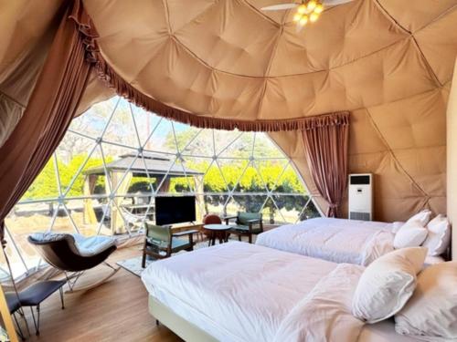 deux lits dans une chambre avec une grande fenêtre dans l'établissement UE GARDEN RESORT - Vacation STAY 12040v, à Tōgane