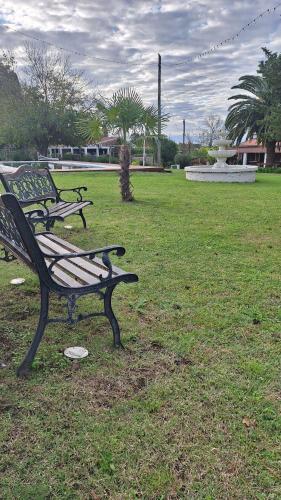 two park benches sitting in a field with a fountain at Amter in San Gregorio de Polanco