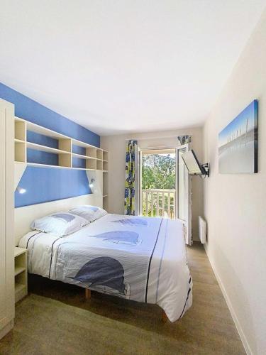 une chambre avec un grand lit avec une tête de lit bleue dans l'établissement Résidence Lacanau Les Pins - Maison tout confort pour 6 personnes dans résidence de tourisme familiale avec piscine MAE-0923, à Lacanau