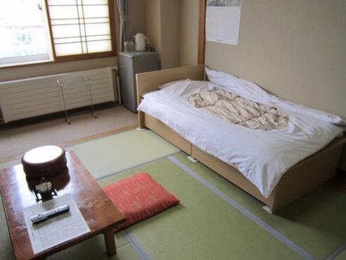 a bedroom with a bed with a table and a coffee table at Yusenkaku - Vacation STAY 92605v in Kombu