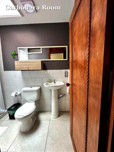 a bathroom with a toilet and a sink at Hostal El Quinde in Salento
