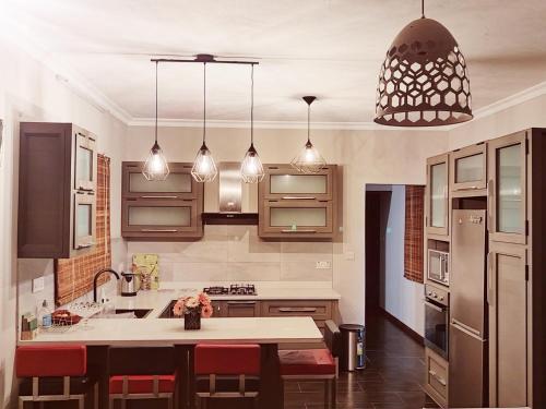 a kitchen with a table and pendant lights at Villa Azalea in Grand Baie