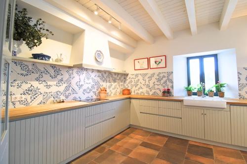 Una cocina con gabinetes blancos y un fregadero y una ventana. en Casa del Angel by SIERRA VIVA, en Los Marines