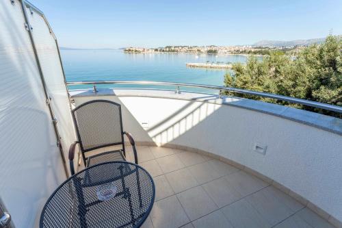 a balcony with a bench and a view of the water at Sunset Split Rooms in Podstrana