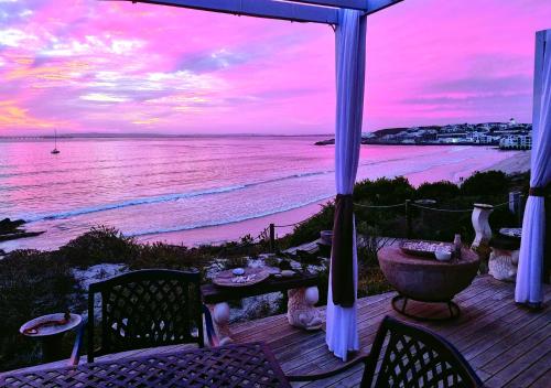 a patio with a view of the beach at sunset at Crystal Lagoon Lodge in Langebaan