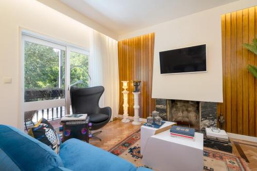 a living room with a blue couch and a fireplace at Serralves 1048 Luxury Villa in Porto
