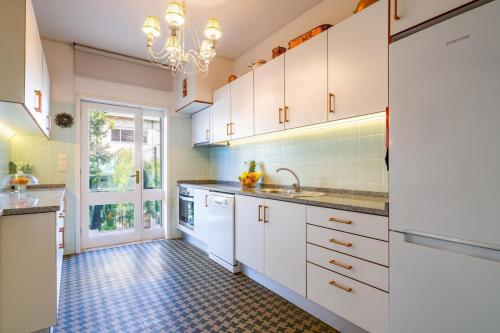 a kitchen with white cabinets and a tile floor at Serralves 1048 Luxury Villa in Porto