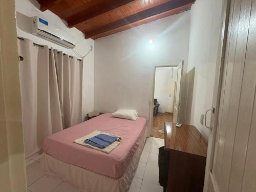 a small bedroom with a pink bed and a mirror at Las Azaleas in Puerto Iguazú