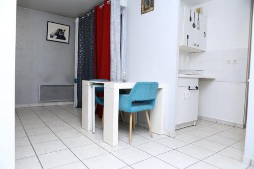 une cuisine avec une table blanche et des chaises bleues dans l'établissement Appartement T2 Confortable à Lyon, à Lyon