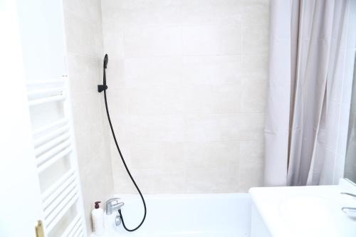 La salle de bains blanche est pourvue d'une douche et d'un lavabo. dans l'établissement Appartement T2 Confortable à Lyon, à Lyon