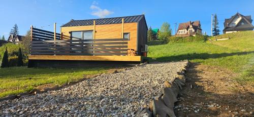 une petite cabane en bois sur une colline avec des maisons en arrière-plan dans l'établissement ECO Domek Tatry Ski out Bukowina, à Bukowina Tatrzańska