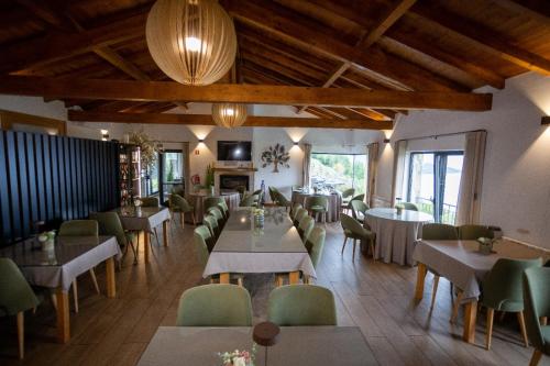 a restaurant with tables and chairs in a room at Casa Albelo do Gerês in Montalegre