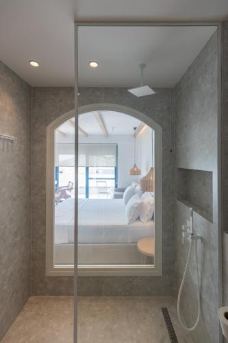 a bathroom with a large glass door to a bedroom at Dimitri Hotel in Himare