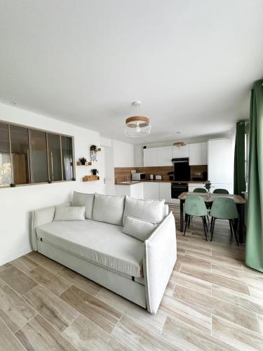 un salon avec un canapé et une cuisine dans l'établissement Bienvenue Chez Annabelle - Meaux, à Meaux