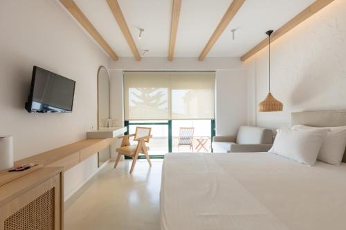 a bedroom with a bed and a desk and a tv at Dimitri Hotel in Himare