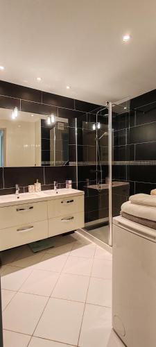 une salle de bain avec un lavabo et un grand miroir dans l'établissement T2 chic non loin de palais festival, à Cannes