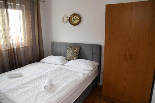 a bedroom with a bed with a clock on the wall at Apartman Katarina in Gradac