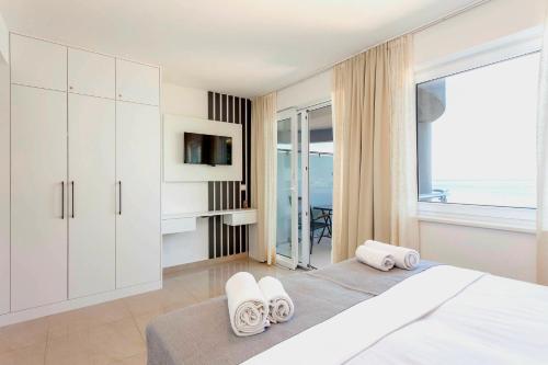 a bedroom with a bed with white cabinets and a window at Sunset Split Rooms in Podstrana