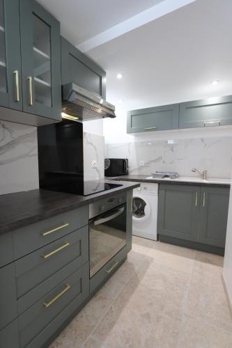 La cuisine est équipée de placards gris et d'un four avec plaques de cuisson. dans l'établissement La case à nous - Entrevennes, à Entrevennes