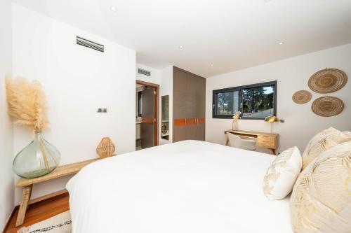 a bedroom with a white bed and a window at Villa luxe dans domaine Mougins in Mougins