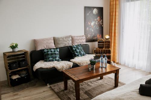 a living room with a couch and a coffee table at Apartment Gelassenheit Geyersberg - dein exklusiver Ort zum Ankommen & Genießen in Freyung