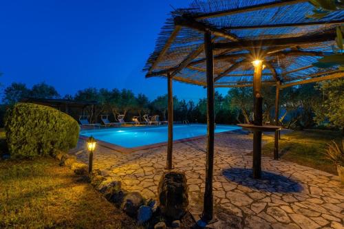 a swimming pool with a pergola and lights next to it at Villa La Lespa W-Pool Biliardo and Lake View in Casa SantʼAndrea