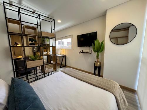 a bedroom with a large bed and a mirror at Cozy Loft in 93 park in Bogotá
