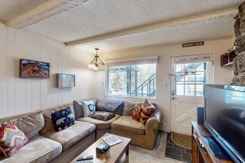 a living room with a couch and a tv at Hi Country Haus Hideaway in Winter Park