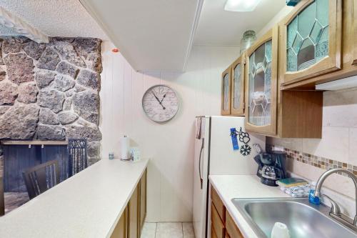 a kitchen with a refrigerator and a clock on the wall at Hi Country Haus Hideaway in Winter Park