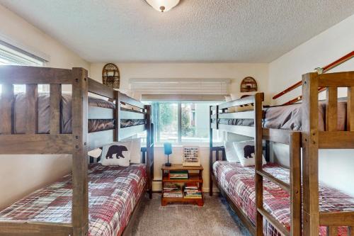 a bedroom with two bunk beds and a window at Hi Country Haus Hideaway in Winter Park